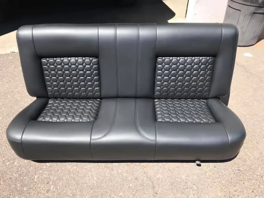 A charcoal leather bench seat with quilted honeycomb inserts.