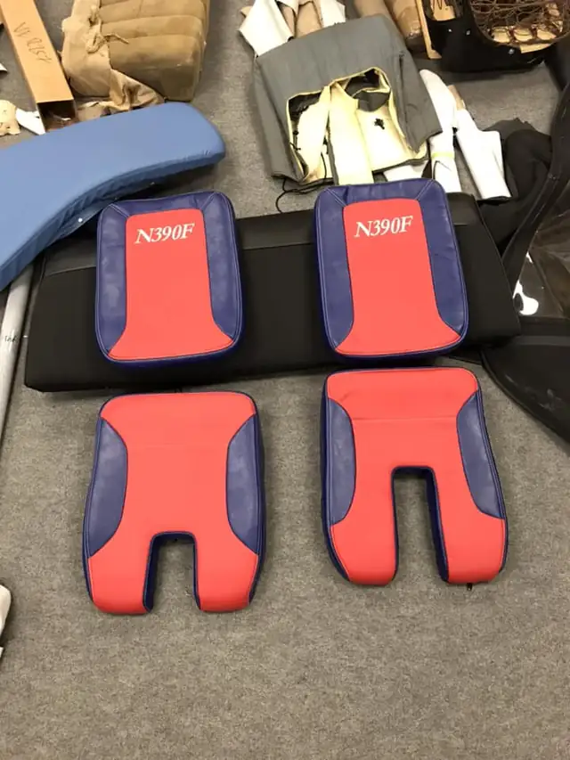 Red and navy seat panels, cut and sewn, on the cutting table.