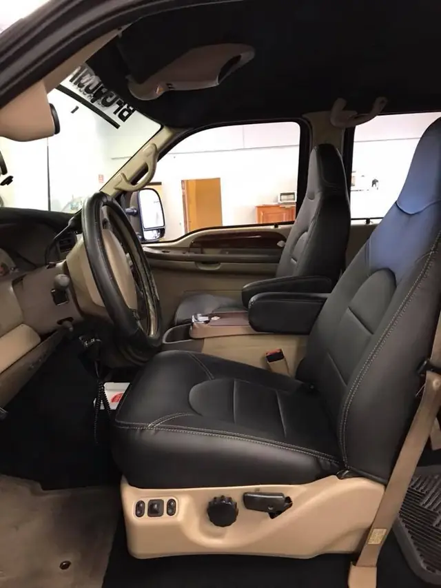 A pickup cab with black leather front seats.