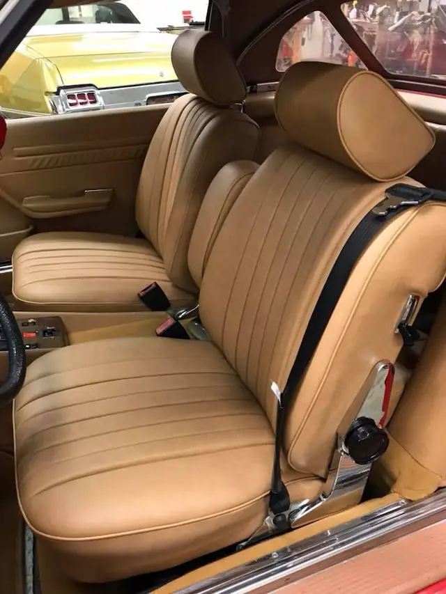 Classic tan leather bucket seats, pleated.