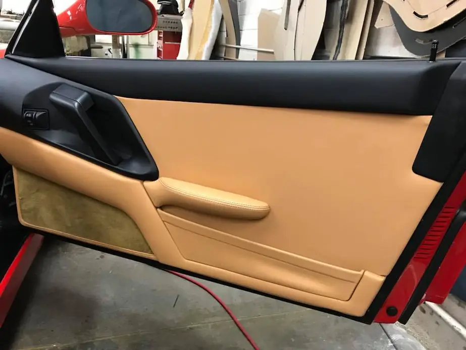 A Ferrari door panel in tan leather.