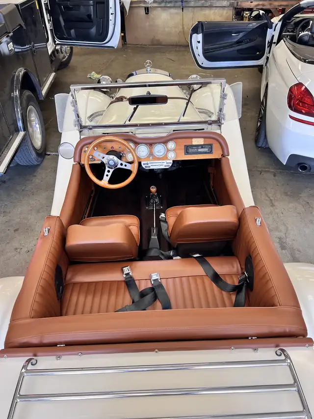 Cognac leather interior of a restored vintage convertible, shot inside the shop bay