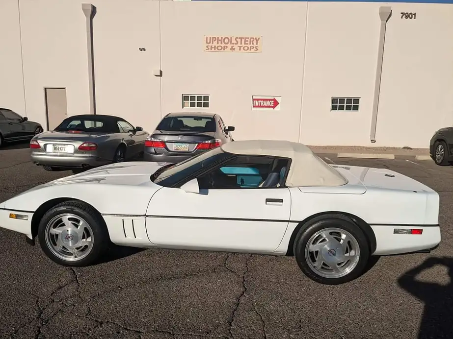 Upholstery Shop & Tops storefront on E Pierce St with a white Corvette convertible out front