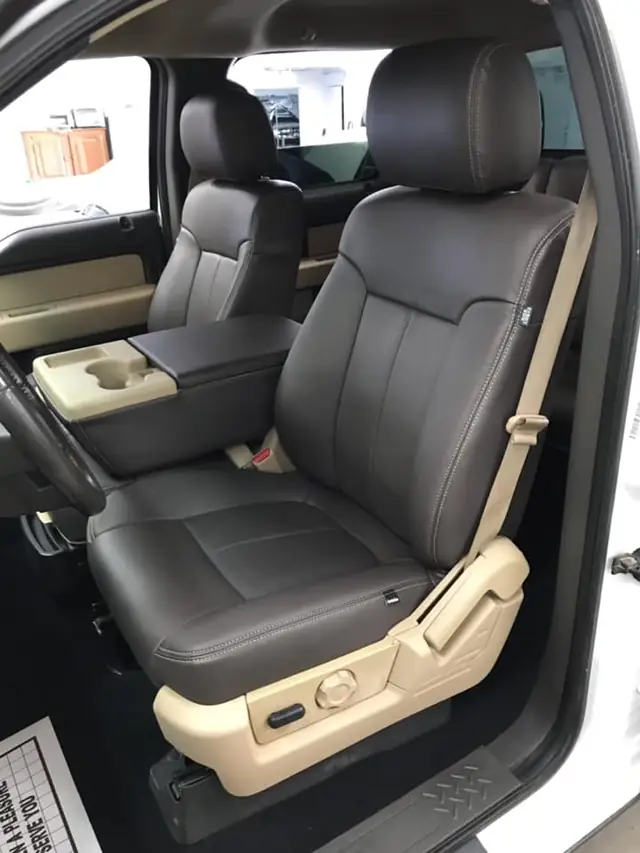 Reupholstered two-tone leather seats in a pickup truck cab.